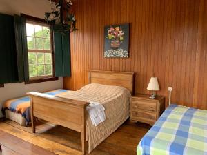 a bedroom with two twin beds and a window at Pouso dos Sinos in Ouro Preto