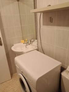 a bathroom with a sink and a washing machine at Studio Cap d'Agde le Môle in Cap d'Agde