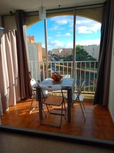 una mesa y sillas en un balcón con vistas en Studio Cap d'Agde le Môle en Cap d'Agde