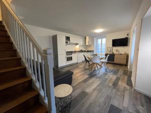 a living room with a staircase and a kitchen at Gîte Le Layris in Campan