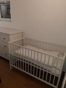 - un lit bébé blanc dans une chambre avec commode dans l'établissement Apartment by Tanja&Nejc, à Bled