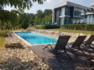 a group of chairs sitting next to a swimming pool at Zlaten Briz Villa in Osenovo