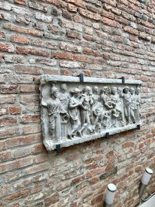 eine Steinskulptur an der Seite einer Ziegelmauer in der Unterkunft Avanguardia Art Club in Ferrara