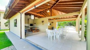 um pátio aberto com cadeiras brancas e uma mesa em Pousada Recanto dos Feijós em Florianópolis