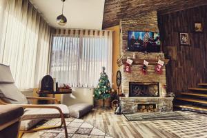 un soggiorno con un albero di Natale e un camino di Къща За Гости Уют Guest House Cozy a Starosel