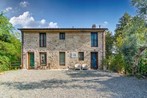 zewnętrzny widok na kamienny dom z niebieskimi drzwiami w obiekcie Dolce Vita in Tuscany B&B w mieście Capannori