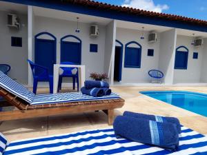 uma villa com uma piscina e cadeiras azuis em Pousada Vila de Charme em Barreirinhas