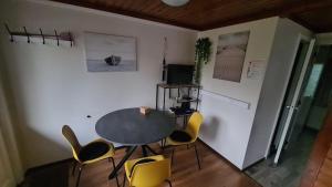 a dining room with a table and yellow chairs at Rent & Relax: De steiger in Geel