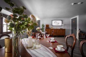 a dining room with a table with a vase of flowers at Viesu nams Donas in Blome