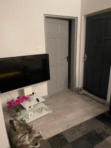 uma sala de estar com uma televisão de ecrã plano e uma porta em Burnside em Oban