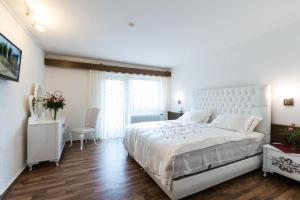Habitación blanca con cama blanca grande y suelo de madera. en Landhotel zum kühlengrund & soultans paradise en Brensbach