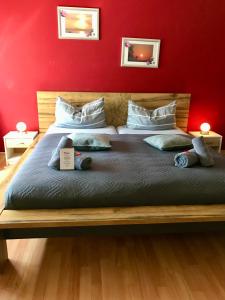 a bedroom with a large bed with a red wall at Komfort-Ferienwohnung Dreilaendereck in Ochtrup