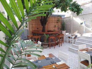 a patio with tables and chairs and a tree at Cole Street Guesthouse in Freetown