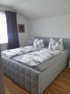 a large bed in a bedroom with pillows on it at Haus Guem in Ehrwald
