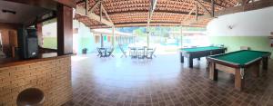 
a large room with a pool table and chairs at Hotel Pousada Nosso Cantinho in Ubatuba
