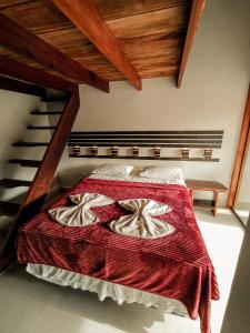a bedroom with a bed with a red blanket at Pousada Recanto da Concha in Itacaré