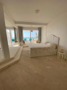 Villa Nº25b Alfredo Marchetti suites on the beach Praia di Chaves في Cabeçadas: غرفة نوم مع سرير وإطلالة على المحيط