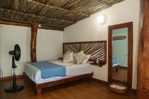 a bedroom with a bed and a mirror at Soy Local Barú in Baru