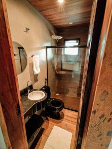 a bathroom with a sink and a toilet and a mirror at Pousada Recanto da Concha in Itacaré