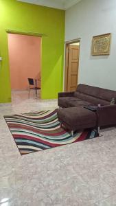 ein Wohnzimmer mit einem Sofa und einem Teppich in der Unterkunft Al-Kautsar Private Pool WIFI Movies Aircond in Kota Bharu