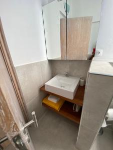 a bathroom with a white sink and a mirror at Villa Nº25b Alfredo Marchetti suites on the beach Praia di Chaves in Cabeçadas