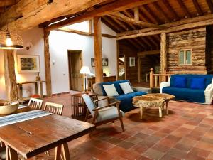 salon z niebieską kanapą i stołem w obiekcie Casona de Saltus, espectacular casona en Sotosalbos,10min de Segovia w mieście Sotosalbos