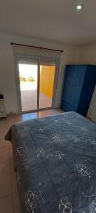 1 dormitorio con 1 cama grande y edredón azul en CASA VERDE II en Carhué