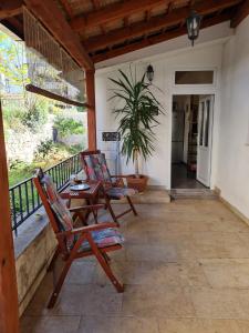 eine Terrasse mit zwei Stühlen und einem Tisch auf einer Veranda in der Unterkunft Quiet apartment in a private house - close to center, parking, pet friendly in Split