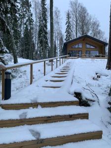 a snow covered staircase in front of a cabin at Villa Korppi in Jorvas