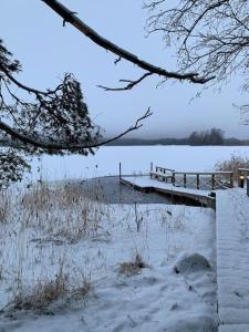 a snow covered bridge over a body of water at Villa Korppi in Jorvas