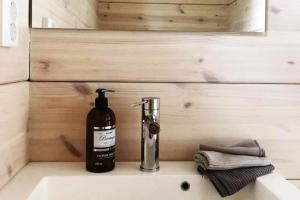 - une bouteille de savon assise sur un lavabo dans l'établissement Villa Korppi, à Jorvas