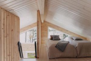 a bedroom with two beds in a wooden house at Villa Korppi in Jorvas