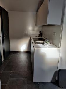 a white kitchen with a sink and a stove at Apartma A1 GOLTE in Mozirska Koča