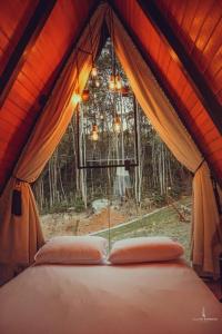 a bed in a tent in front of a window at Chalé Audaz in Orleans
