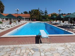 a swimming pool with lounge chairs and a resort at Lobateira Villas in Fernao Ferro