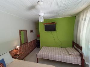 a room with two beds and a green wall at Hospedagem Recanto dos Ties in Abraão