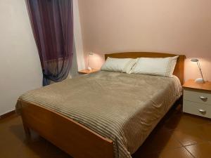 a bedroom with a bed with a wooden headboard at Lago e Monti in Colico