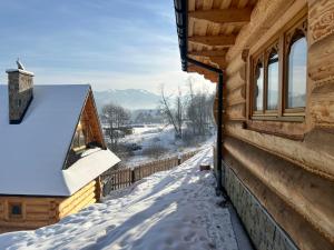 a log cabin in the snow with a window at Tatra Break in Witów