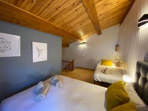 a bedroom with two beds in a room with wooden ceilings at Prober-Mundial in Pas de la Casa