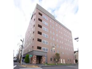 een groot bruin gebouw in een stadsstraat bij R&B Hotel Kumagaya Ekimae - Vacation STAY 40478v in Kumagaya