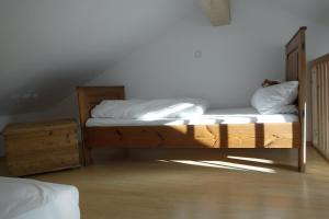 Schlafzimmer mit einem Holzbett mit weißer Bettwäsche in der Unterkunft Appartement - Ferienwohnung - FeWo Obernkammer in Emmering