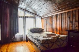 a small bed in a room with a window at Family hotel Andreev in Dobrinishte