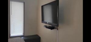 TV de pantalla plana colgada en la pared en Rock Creek Mercantile & Motel en Clinton