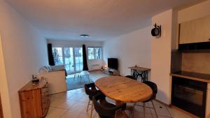 a living room with a wooden table and chairs at Appartement avec terrasse ensoleillée in Gruyères