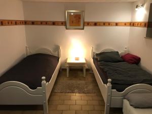 2 Betten in einem Zimmer mit einem Tisch und einer Lampe in der Unterkunft Ferienwohnung Sandner in Porta Westfalica