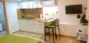 a small kitchen with a counter and stools in a room at Studio Jadro in Selce +6 photos