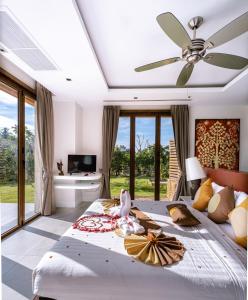 una camera con un grande letto e un ventilatore a soffitto di VILLA DIVA STAR a Ko Yao Noi