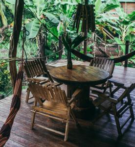 uma mesa e cadeiras de madeira num deque de madeira em ENSUEÑOS Natural Reserve Big House em Corn Island