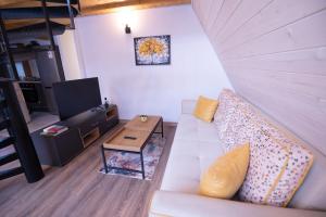 a living room with a couch and a tv at Scandinavia A-Frame in Akhundov