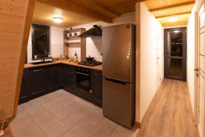 a kitchen with black cabinets and a stainless steel refrigerator at Scandinavia A-Frame in Akhundov